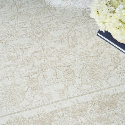 Beige patterned rug with subtle vintage motifs; cream hydrangea bouquet atop navy hardcover books in top-right.