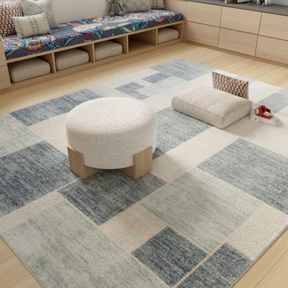Geometric blue and cream area rug in a bright living room with a round white tufted pouf and beige ottoman