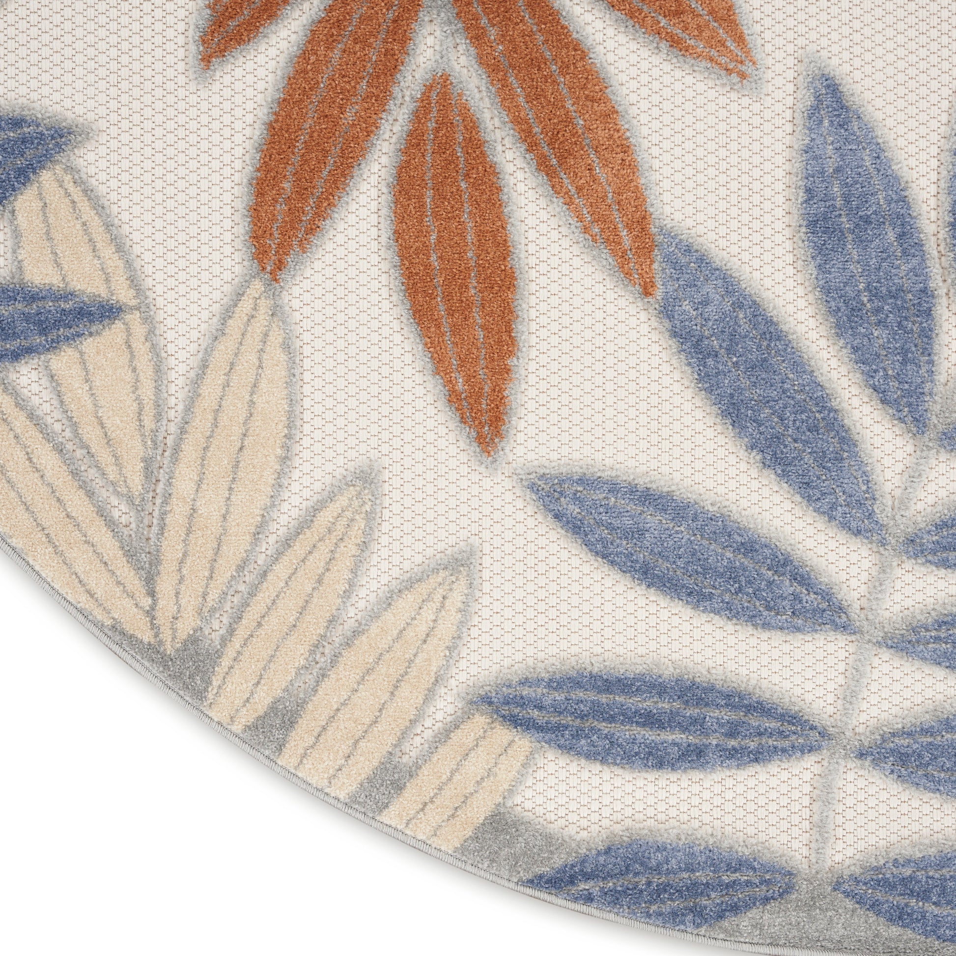 Round rug with blue, beige and orange leaf motifs on cream background; soft textured pile.