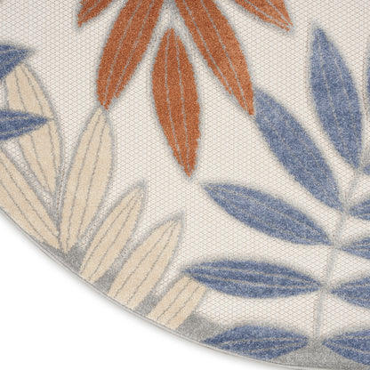 Round rug with blue, beige and orange leaf motifs on cream background; soft textured pile.