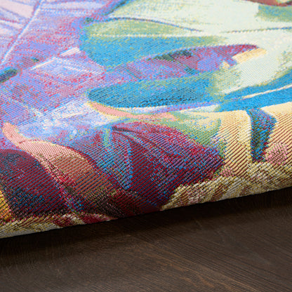 Vibrant multicolor jacquard tapestry-style pillow cover with abstract floral pattern on dark wood surface