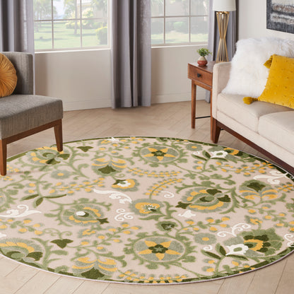 Outdoor round rug, 5' diameter, green, yellow and ivory floral pattern on beige; durable outdoor woven texture.