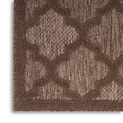 Brown woven rug with geometric quatrefoil trellis pattern in tan & chocolate hues.