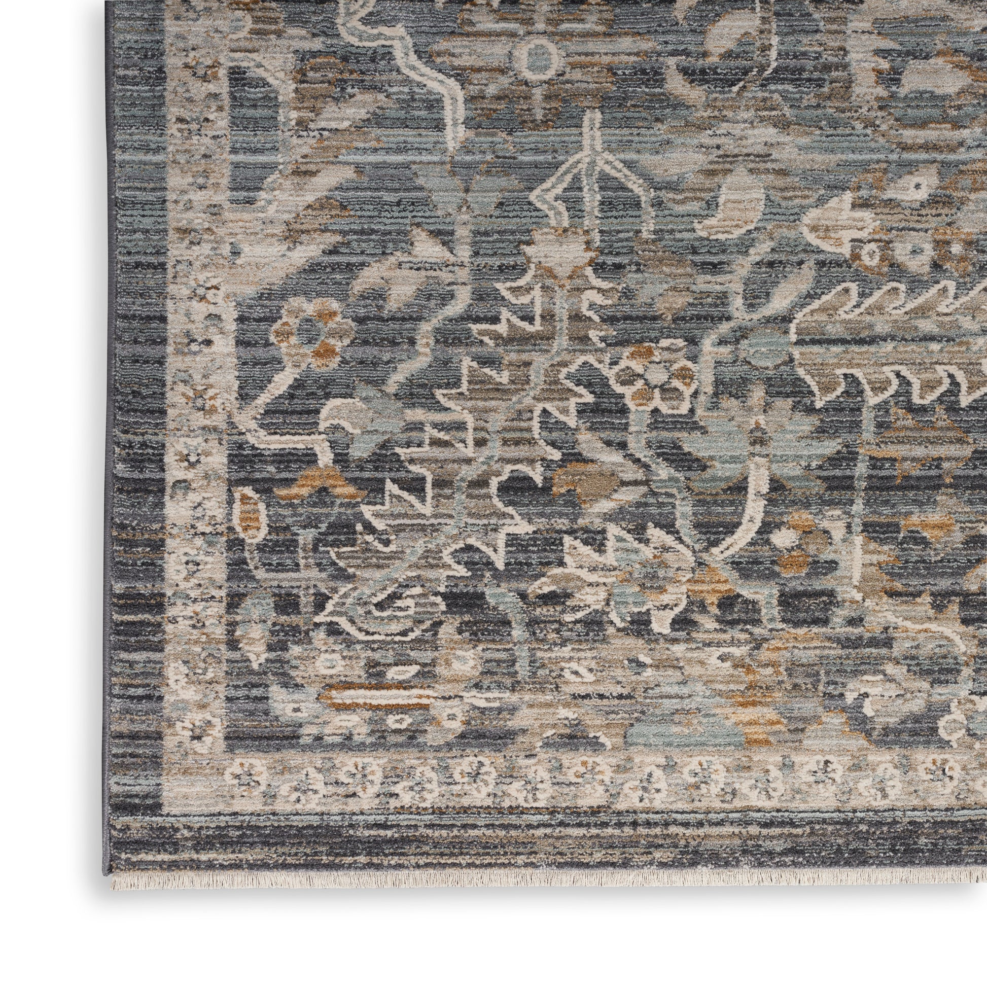 Persian-style rug corner with blue-gray field, ivory and tan floral motifs, and decorative border with fringe.