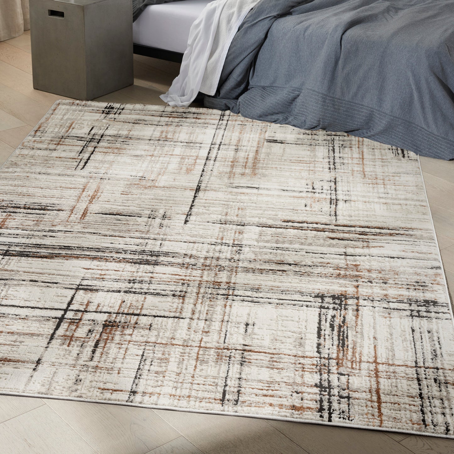 Neutral abstract area rug in beige, cream, black and rust with a geometric linear grid pattern for a modern bedroom.