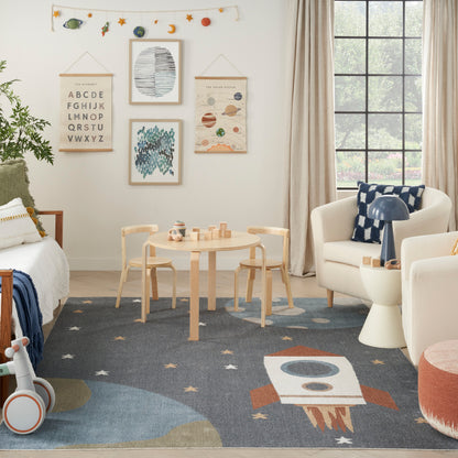 Cozy kids' playroom with light wood furniture, space wall art, star garland, round table, rocket rug, white sofa and blue cushions.