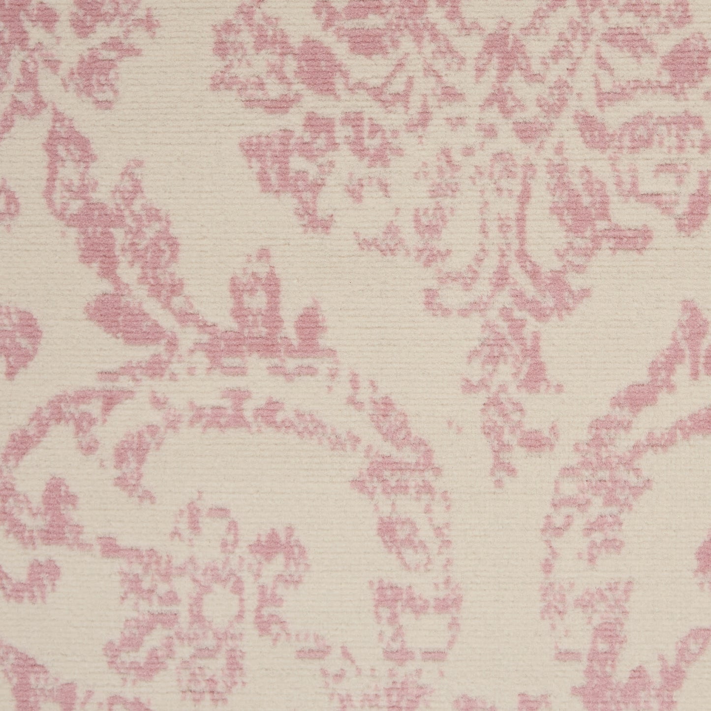 Cream-beige rug with pink damask floral pattern and a subtle woven texture.
