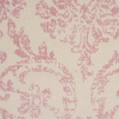 Cream-beige rug with pink damask floral pattern and a subtle woven texture.