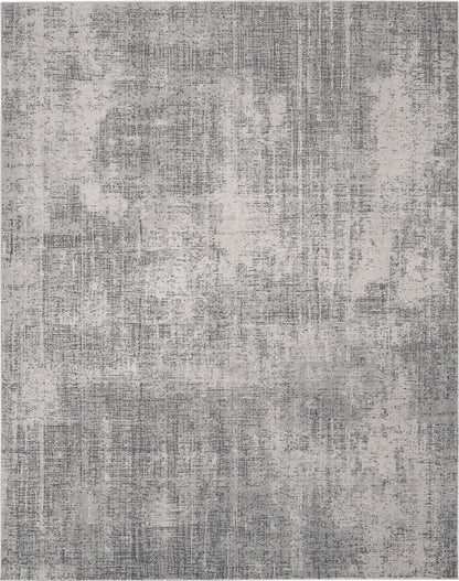 Rectangular gray area rug with abstract, distressed pattern in light and dark gray tones; modern living room decor.
