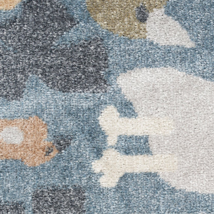 Close-up of a textured shag rug with abstract blue-gray, white, beige & charcoal shapes.