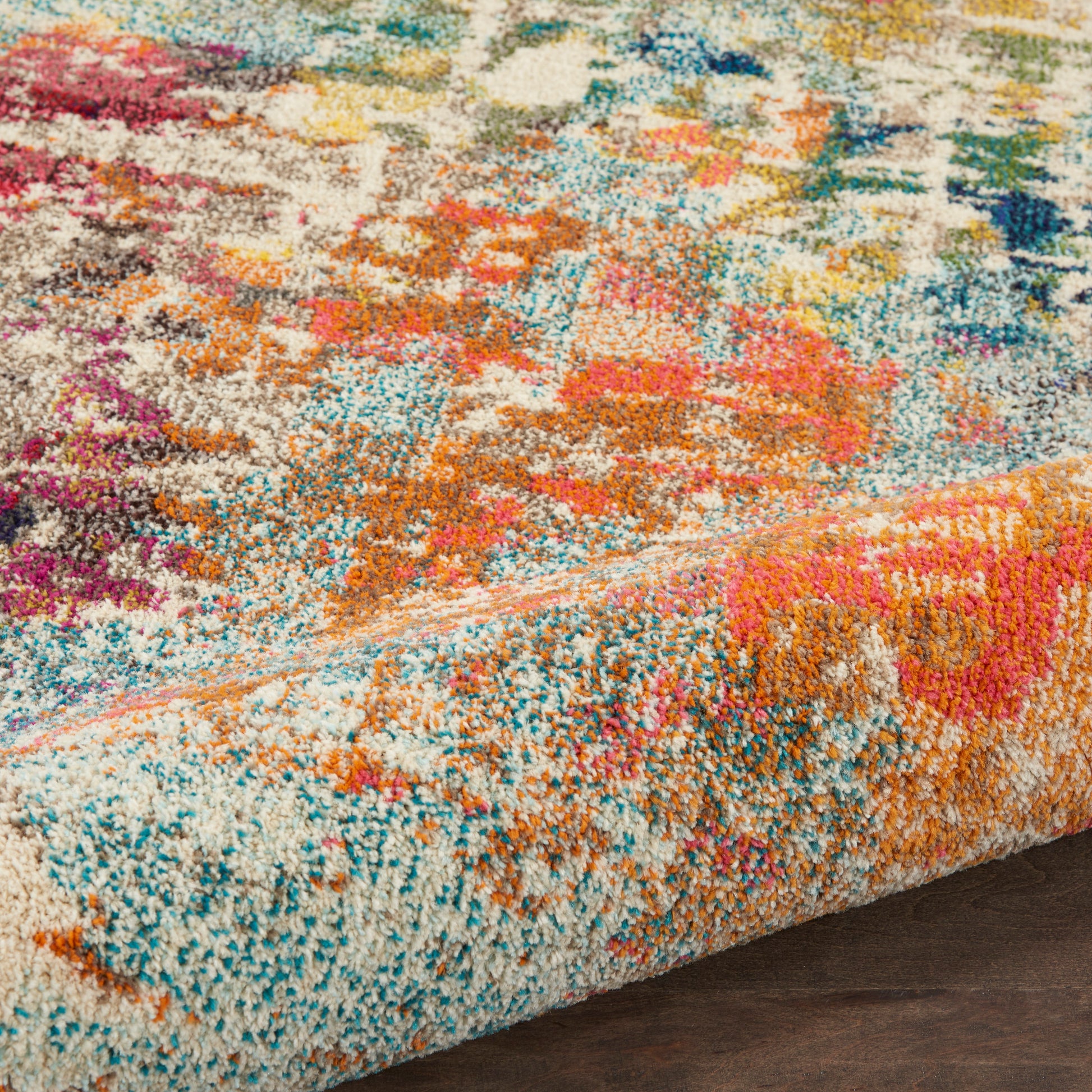 Vibrant multicolor shag rug with plush cut-pile texture in teal, orange, pink, blue; rolled border edge.