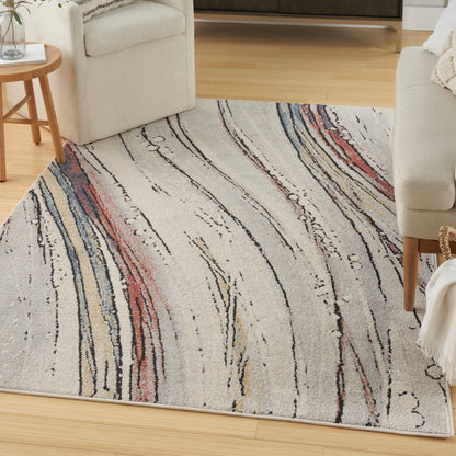 Rectangular cream rug with abstract multicolor wavy lines in red, blue, beige and black on a light wood floor.