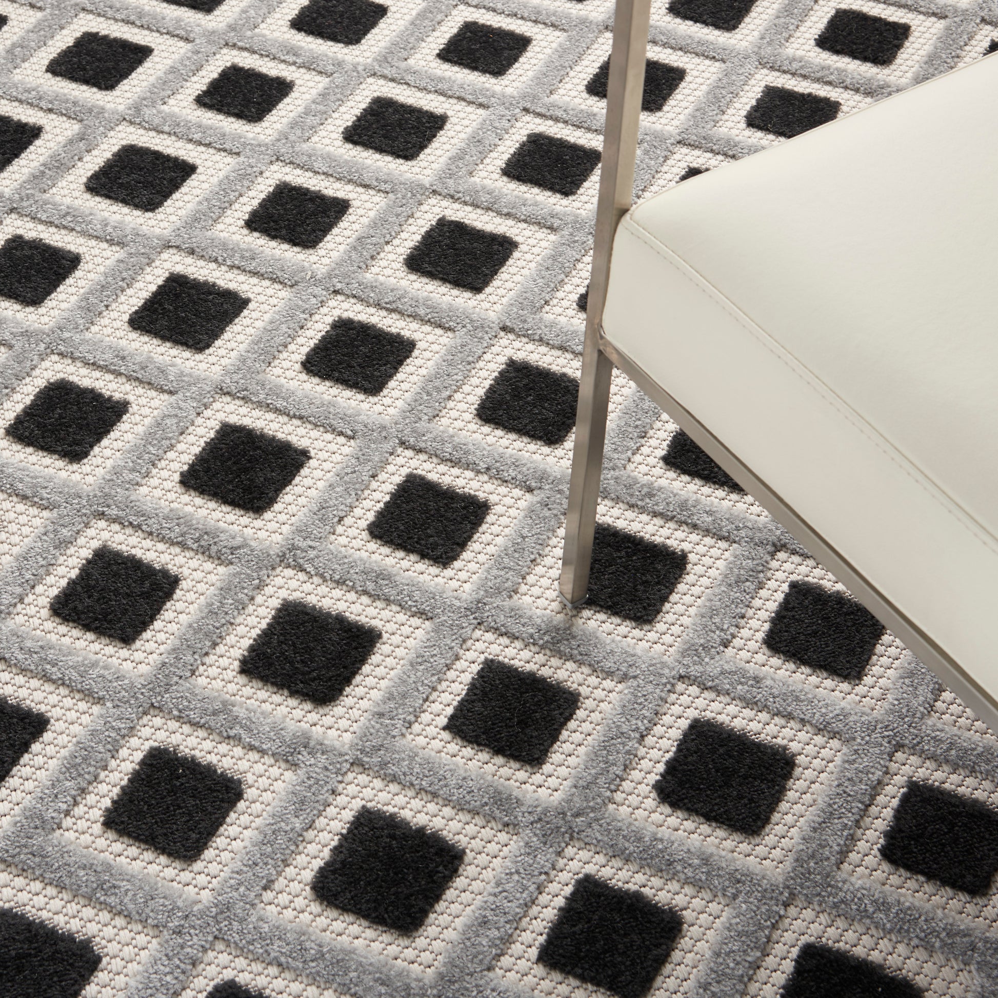 Cream and gray geometric rug with a repeating grid of black square centers.