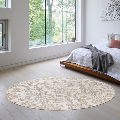 Round beige patterned rug in a bright minimalist bedroom with a low wooden bed and white bedding and gray throw.
