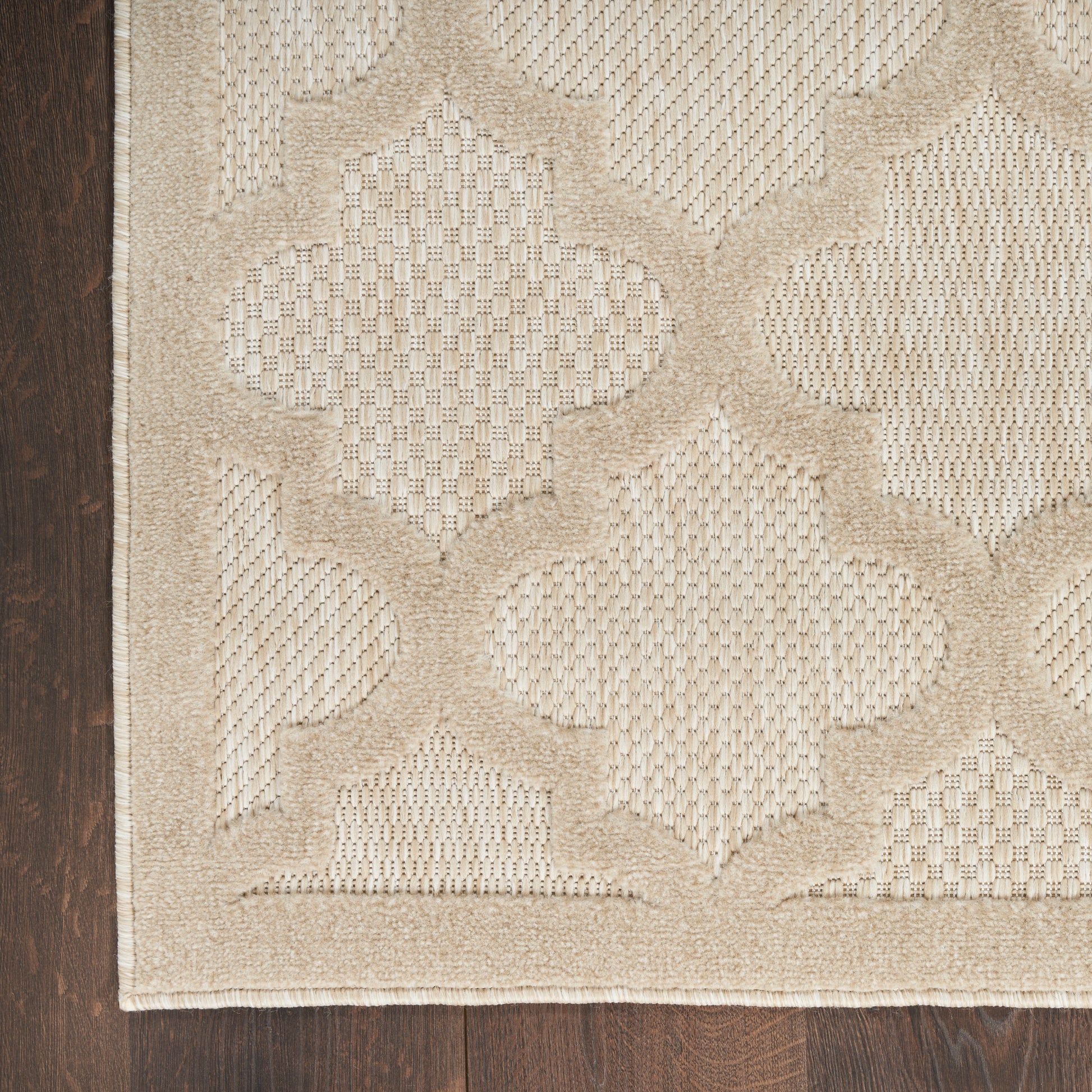 Beige geometric modern runner rug with a raised lattice/quatrefoil pattern on dark wood floor; warm, neutral woven look.