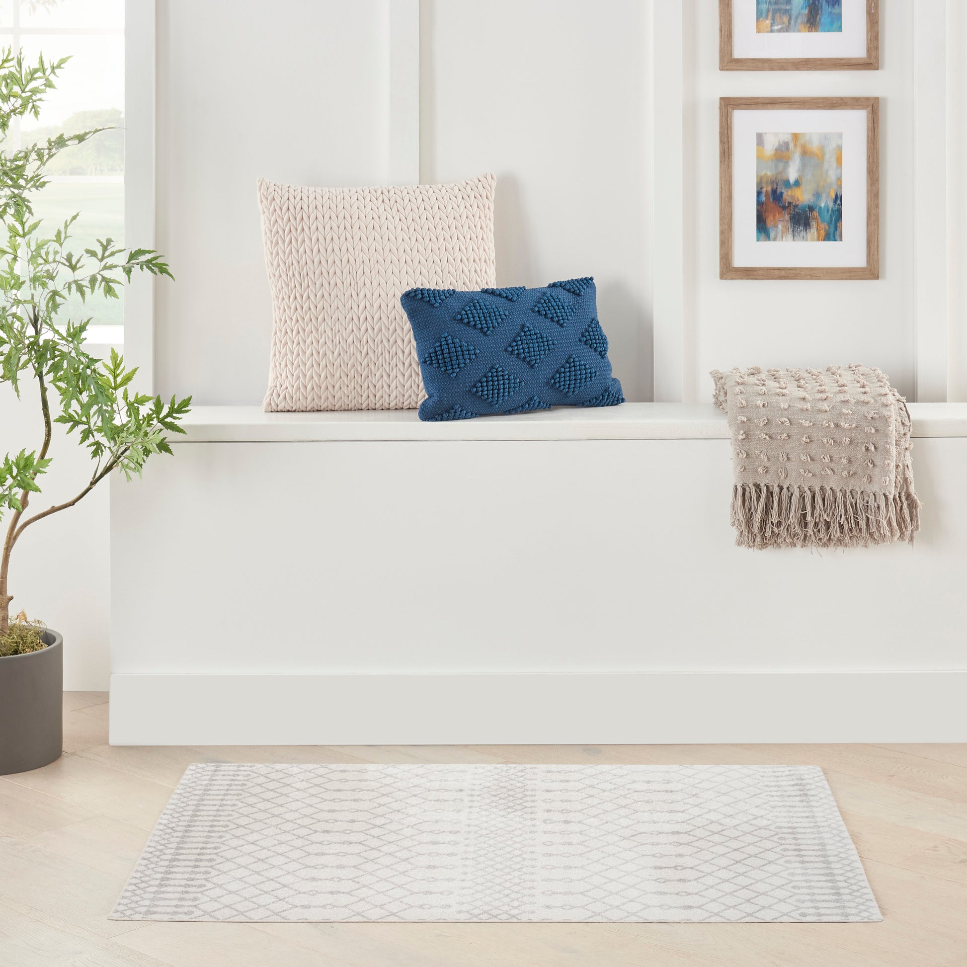Beige bohemian 2' x 4' rug with blue accents, visible beside a potted plant.