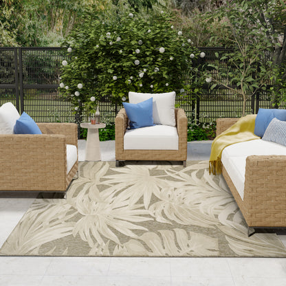 Palm-leaf rug in an outdoor setting with white cushions, blue pillows, a round side table, and surrounding greenery.