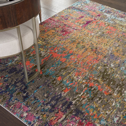 Colorful abstract area rug with vibrant multicolor pattern on a wood floor beside a chair.