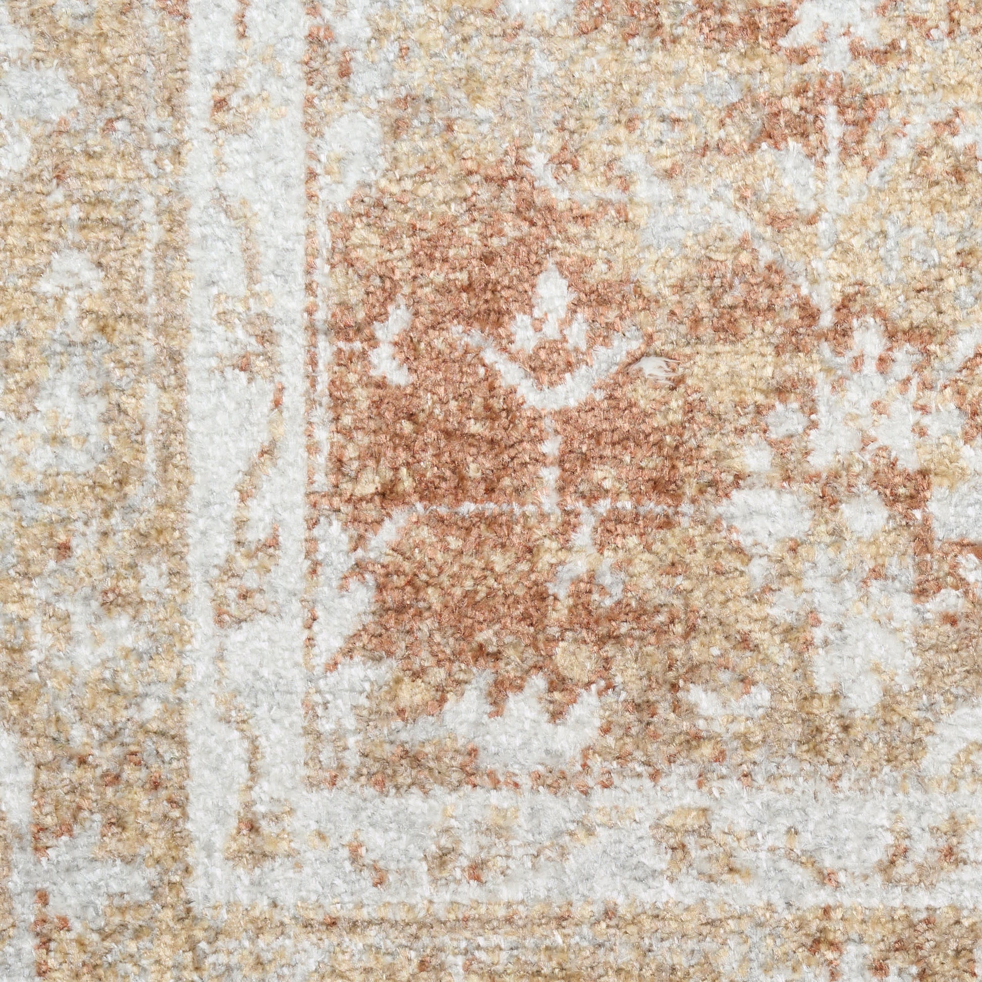 Close-up of a soft, distressed beige and ivory oriental-style woven rug with rust accents and decorative border.