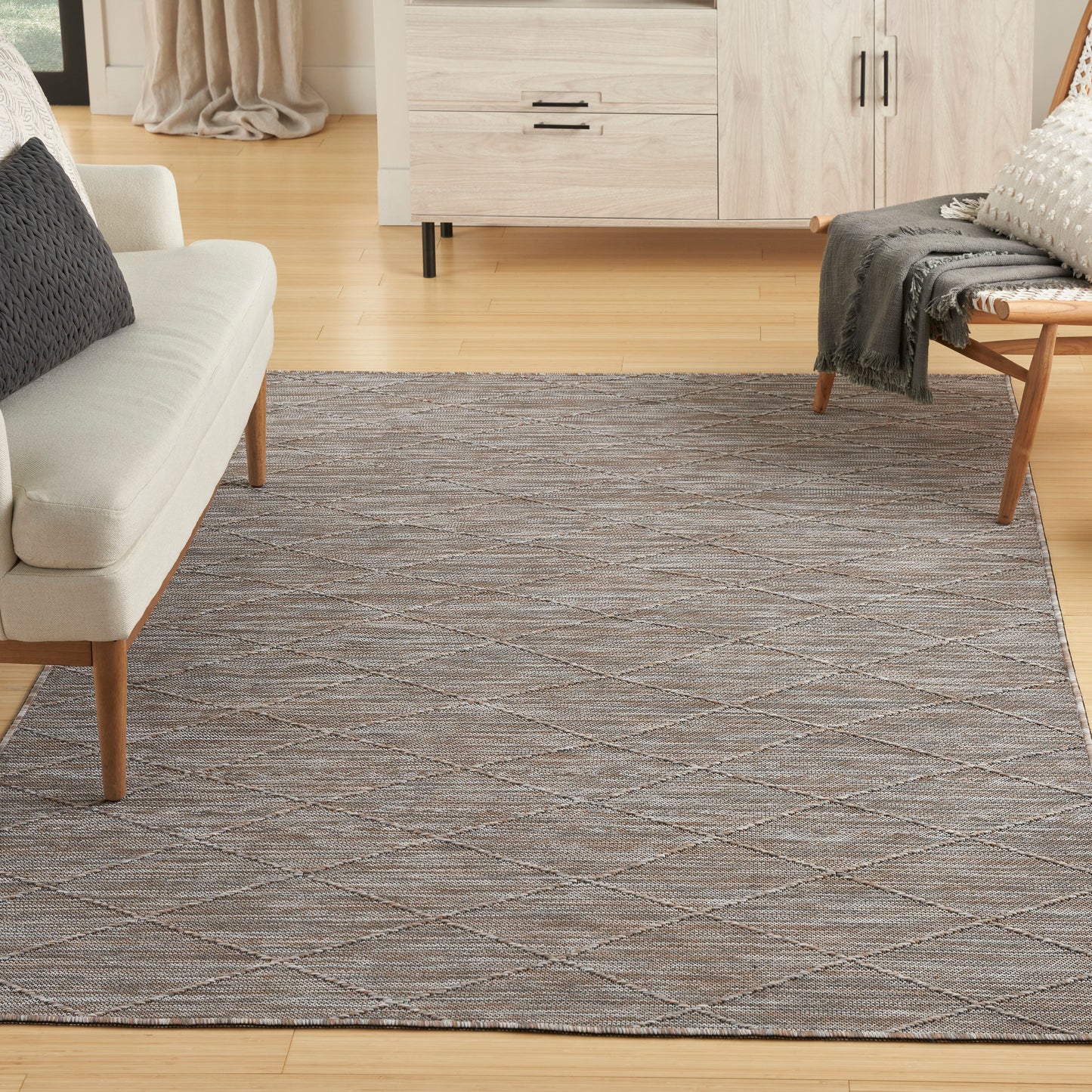 Large neutral-toned woven area rug with gray and taupe diamond lattice pattern in a modern living room.