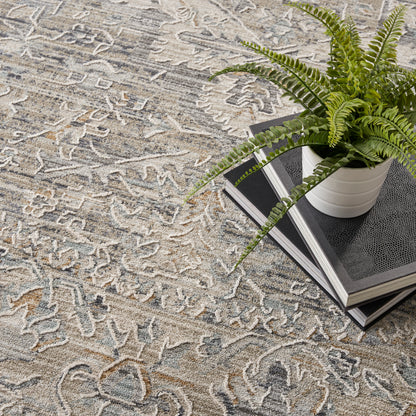 Green fern in a white ceramic pot atop stacked books on a beige-gray patterned oriental rug.