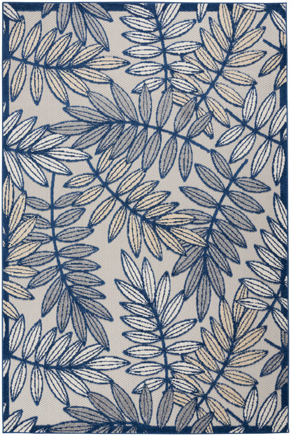 Navy blue botanical rug with a cream-beige backdrop, featuring a dense fern-like leaf pattern and a dark blue border.