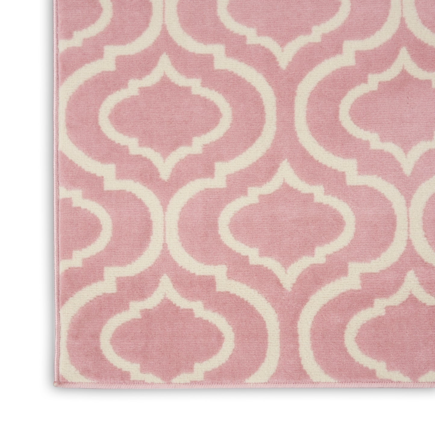 Pink rug featuring cream-white trellis lattice pattern; soft woven fabric, geometric Moroccan-inspired decor.