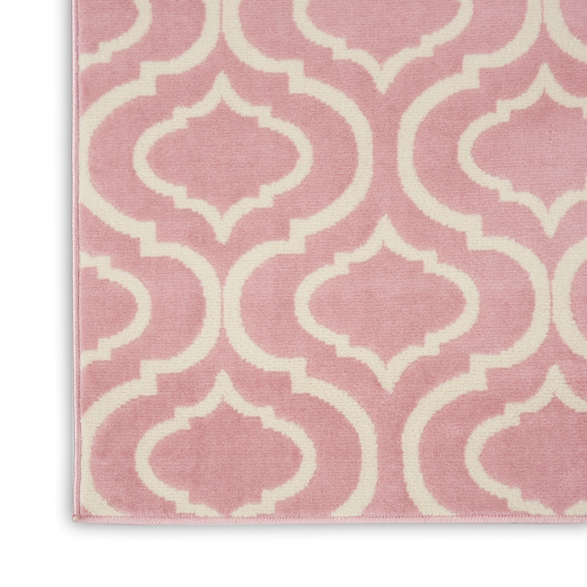 Pink rug featuring cream-white trellis lattice pattern; soft woven fabric, geometric Moroccan-inspired decor.