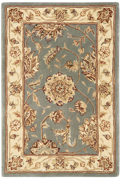 Traditional oriental rug with a blue field featuring a central floral motif and ivory border with burgundy accents.