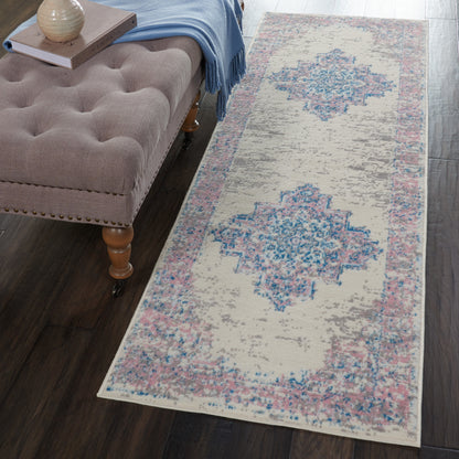Beige distressed runner rug with blue and pink geometric medallions beside a brown tufted bench on dark wood floor.