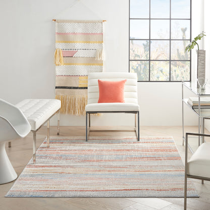 Bright modern living room with white lounge chair, pastel striped rug, wall tapestry, large grid window, coral pillow.