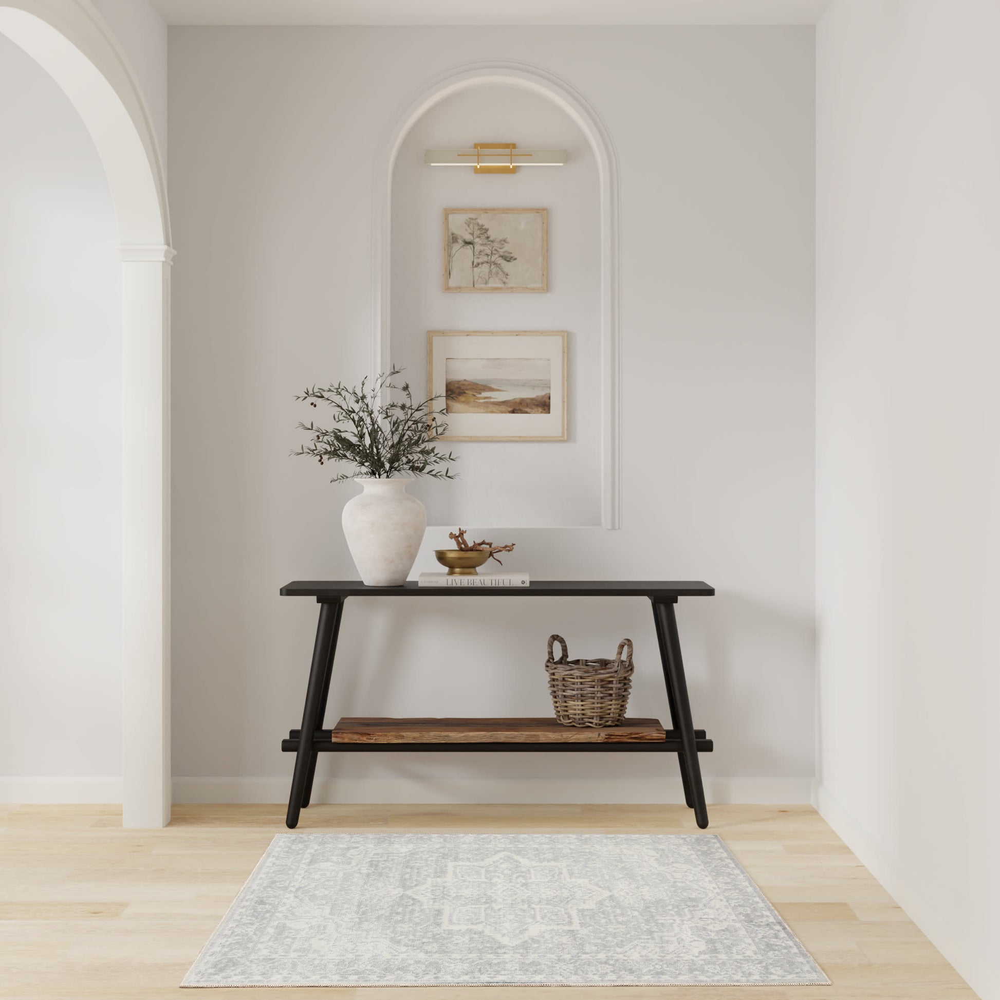 Black two-tier mid-century console in an arched alcove with greenery vase, framed art, basket, and gray patterned rug.