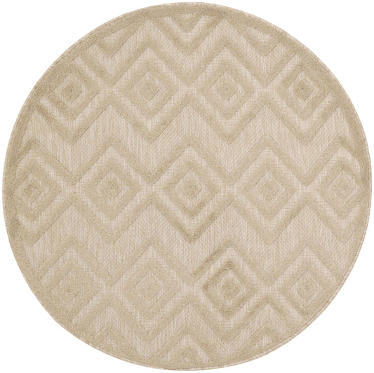 Round beige rug featuring a geometric diamond and chevron pattern with a textured woven surface.