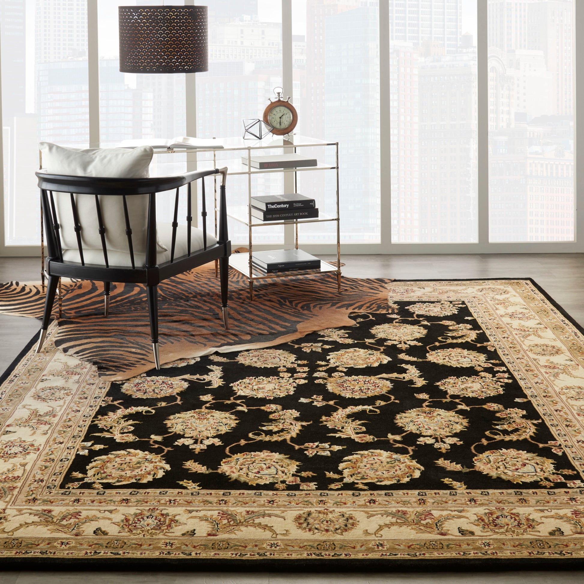 Luxurious black Persian-style area rug with gold floral medallions and beige ornate border, layered over a tiger-print rug.