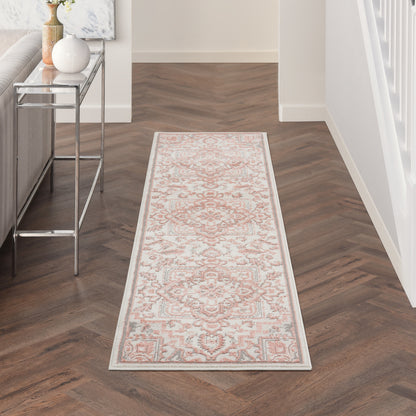 Long runner rug with ivory background and pink floral motif, pale blue border; Persian-inspired hallway decor.