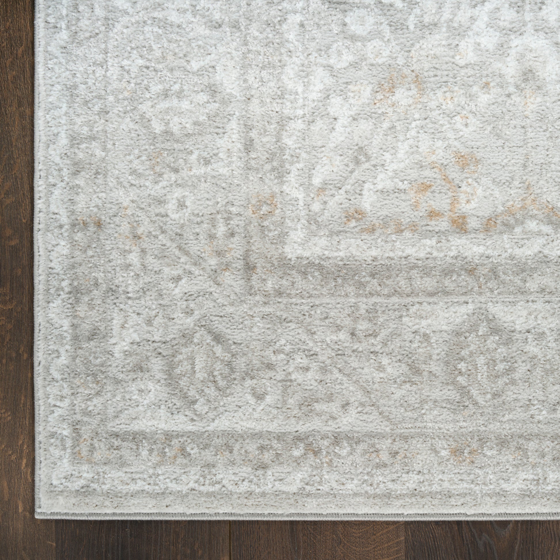 Rectangular light gray distressed patterned area rug with subtle beige motifs; soft pile for living room decor.