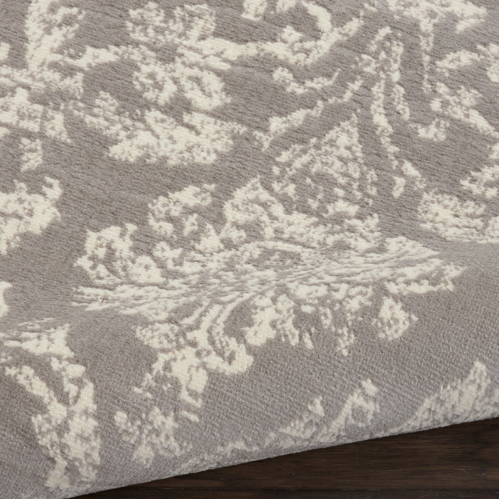 Grey rug with ivory damask floral pattern; plush texture, rectangular shape, ideal for living rooms.