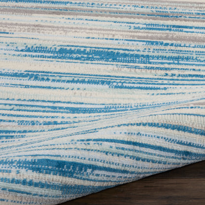 Blue and white striped woven rug with soft brushed pattern, folded corner on dark wood floor.