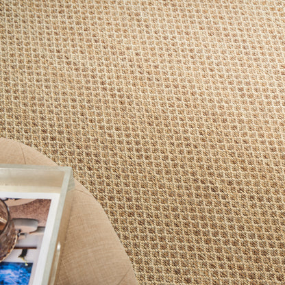 Beige woven textured rug with a round beige side table and a photo book on it.