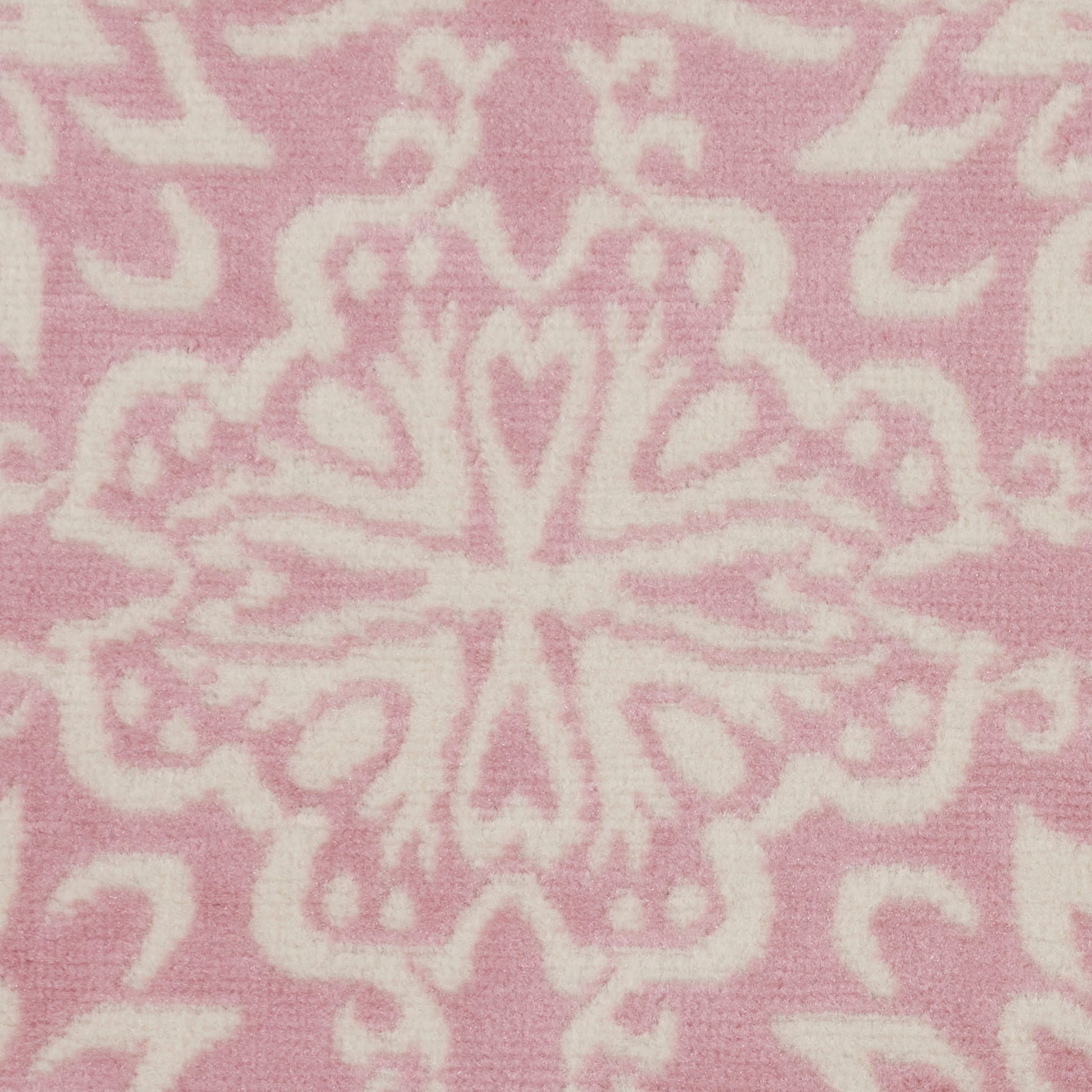 Soft pink fabric with white ornate damask pattern and symmetrical floral motifs.