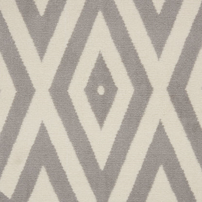 Grey and cream diamond chevron rug with a textured woven surface and repeating geometric pattern.