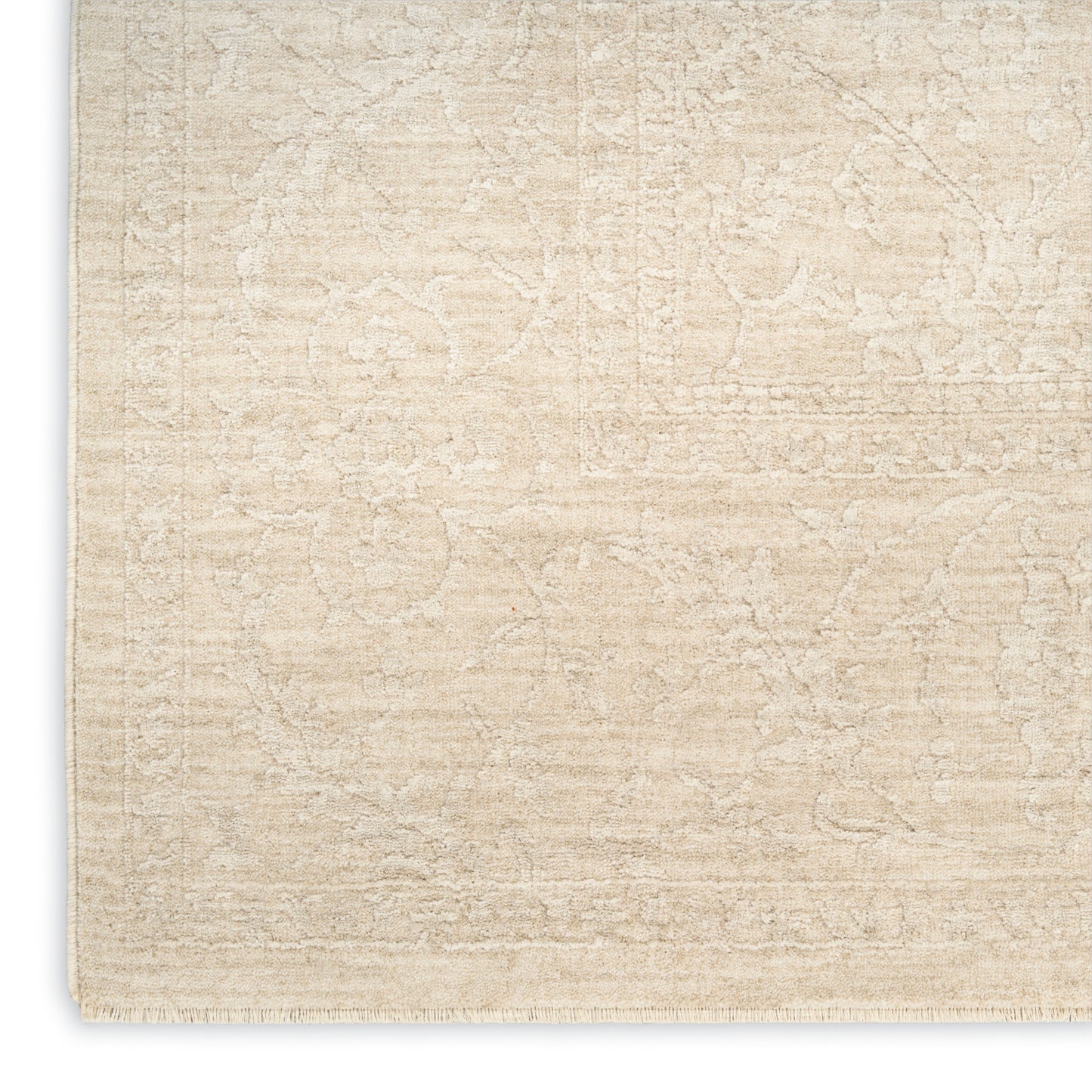 Cream-beige distressed Persian-style area rug with subtle floral motif and fringe edge