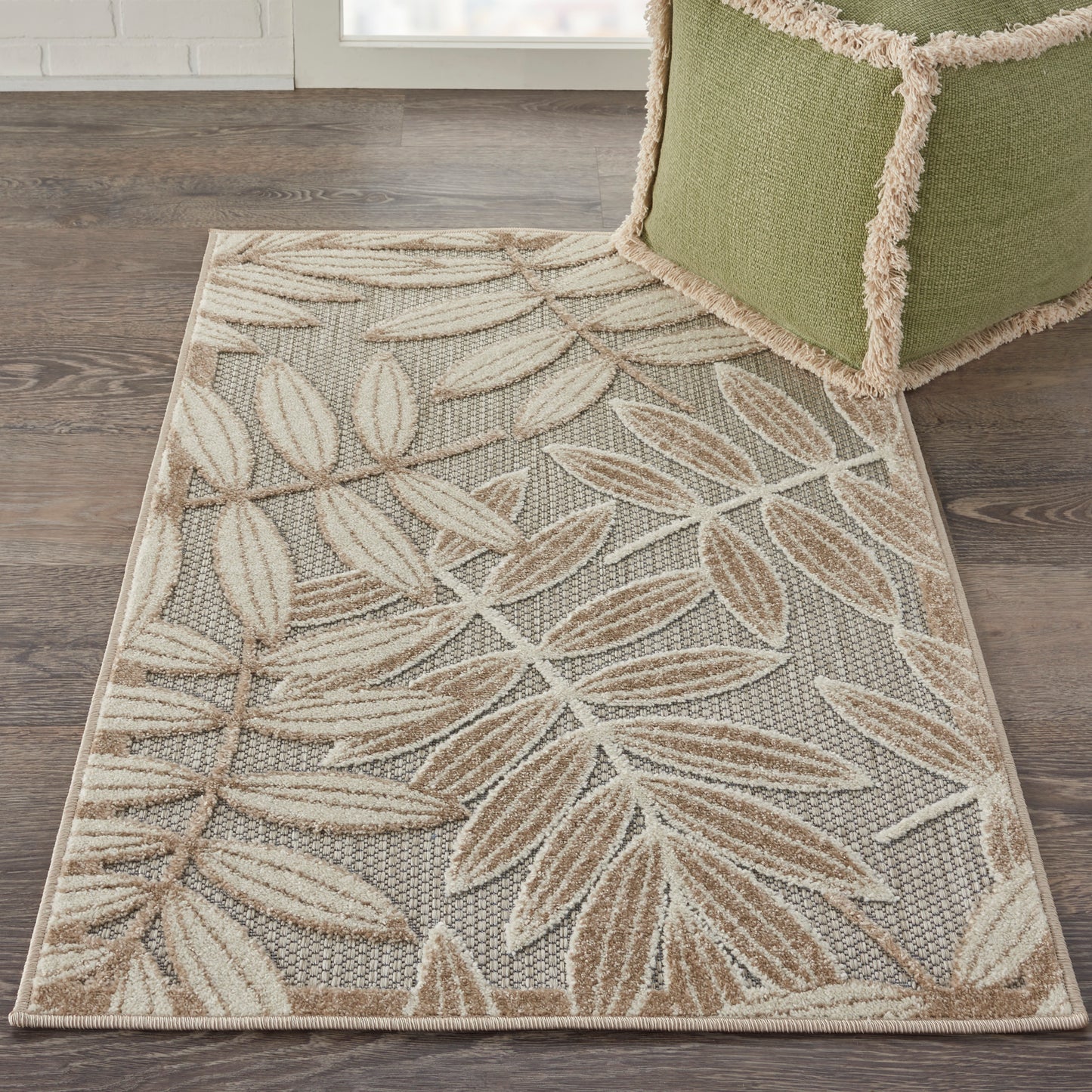 Rectangular woven area rug with beige and tan leaf pattern on gray background; neutral, textured living room rug.