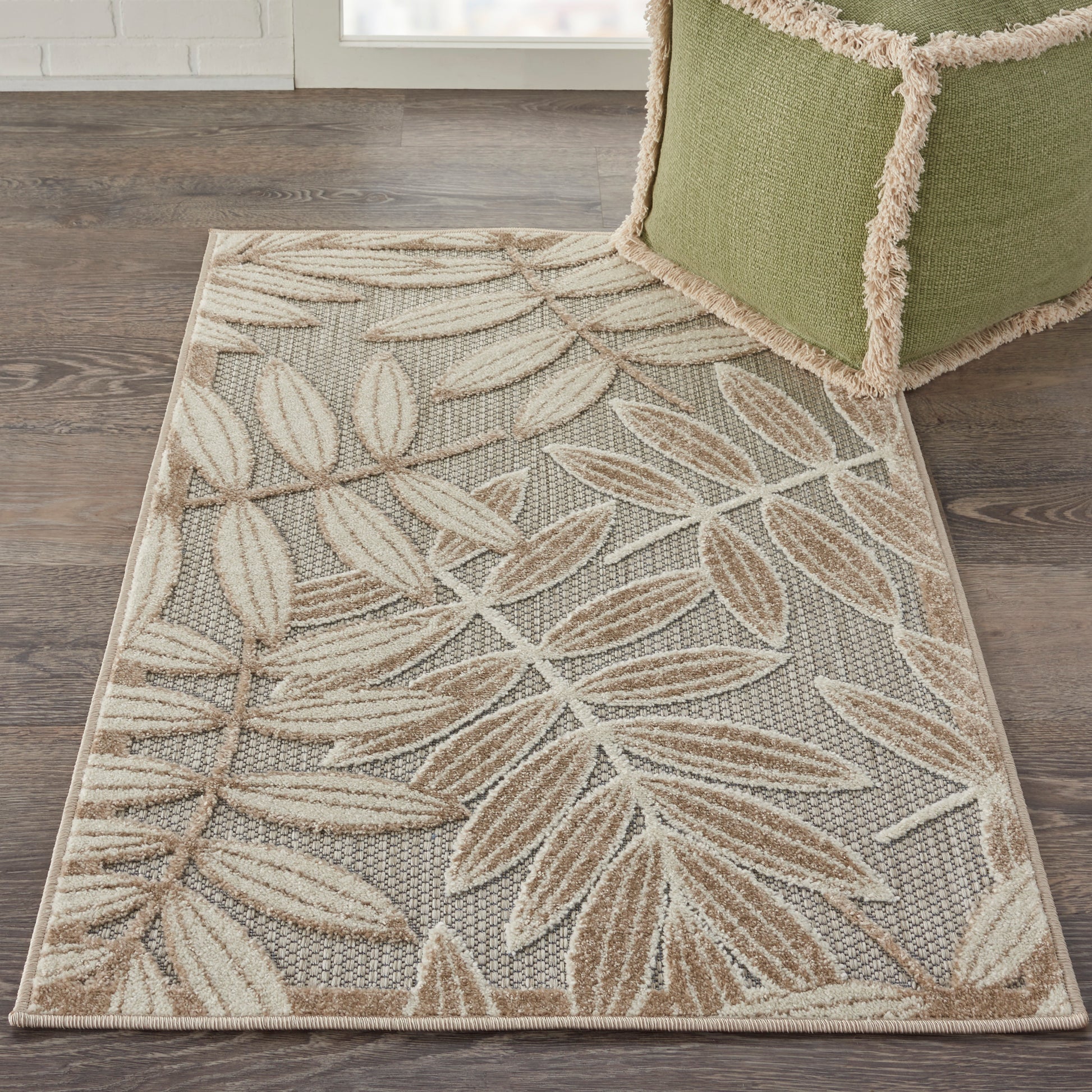 Rectangular woven area rug with beige and tan leaf pattern on gray background; neutral, textured living room rug.