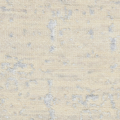 Cream-beige tufted area rug with subtle gray flecks and a soft plush pile.