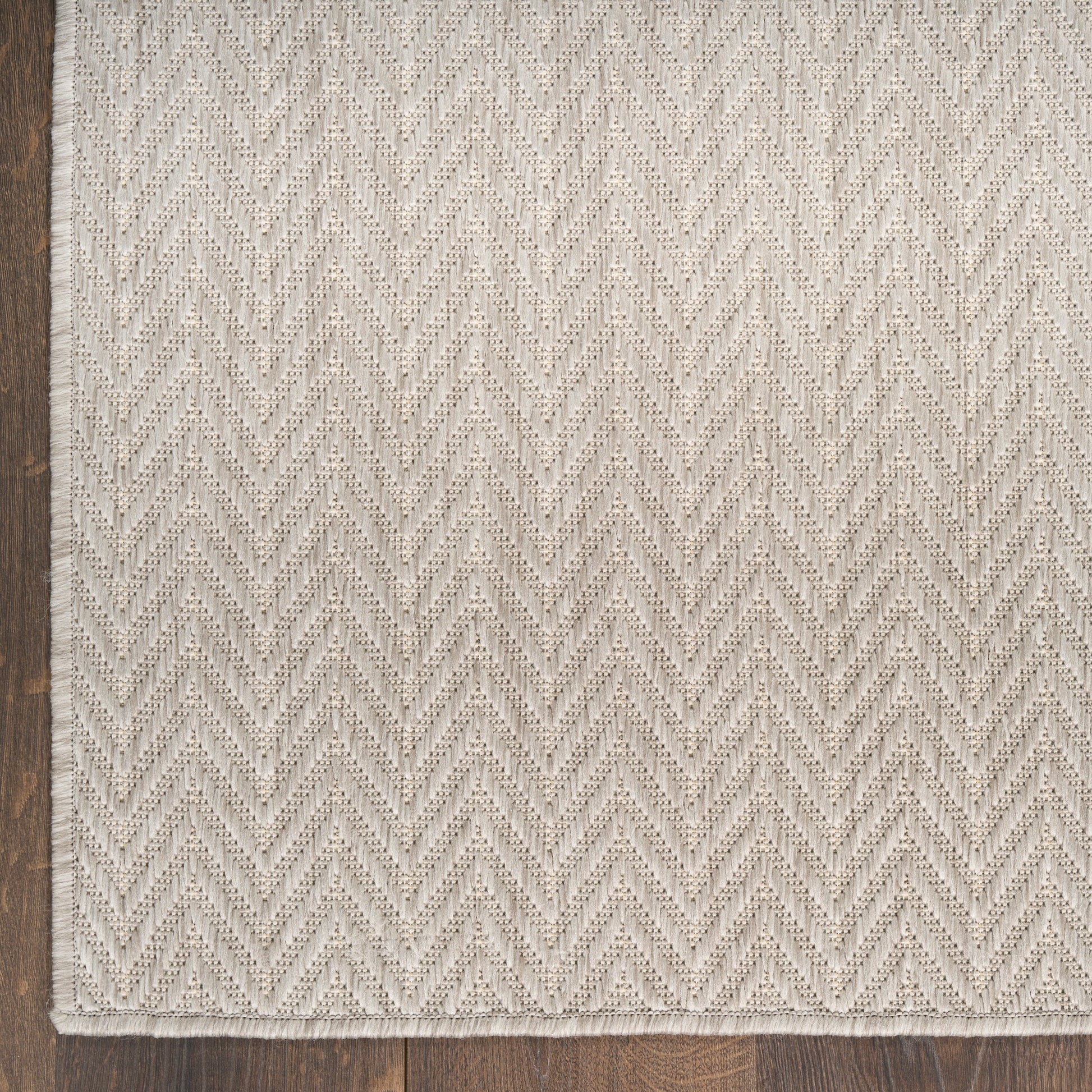 Cream woven rug with a herringbone pattern and fringed edge; soft textured cotton-look for living room decor.