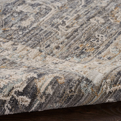 Close-up of a textured oriental rug with blue, gray, beige and cream tones; woven pile and medallion pattern.