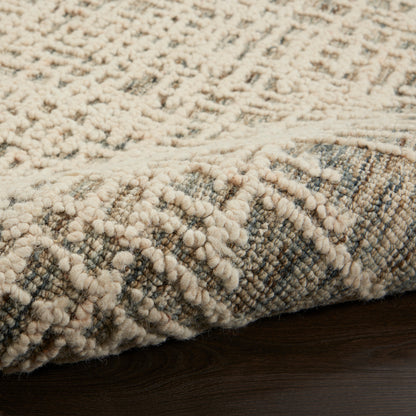 Cream-beige shag rug with dense chunky loops and a textured pattern on dark wood floor.