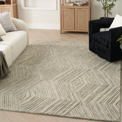 Light gray geometric area rug with zigzag maze pattern; plush fibers in a modern living room with white sofa and dark chair.