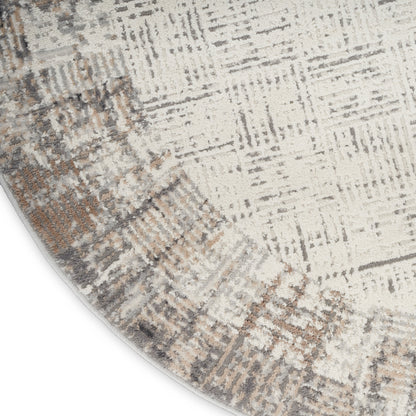 Round abstract-pattern rug in beige, gray and taupe with distressed geometric motifs; soft pile.